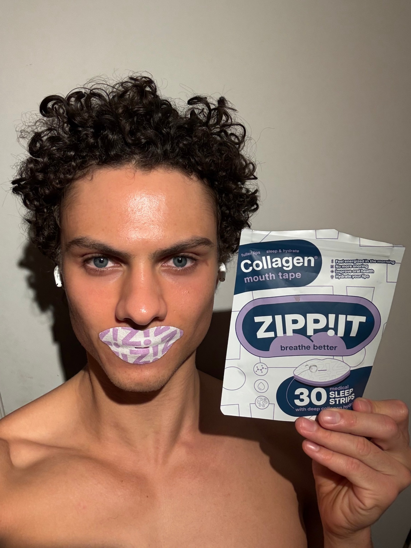 Person wearing Zippit collagen mouth tape holding the pouch